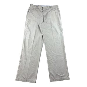 May include: Khaki-colored pants with a straight leg design. The pants have a button and zipper closure, along with front and back pockets. The fabric appears to be a lightweight material, suitable for casual wear.