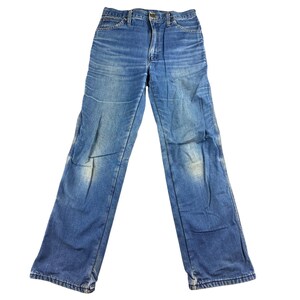 May include: Faded blue denim jeans with a classic five-pocket design. The jeans have a straight leg cut and show signs of wear and fading, giving them a vintage look. The jeans are buttoned at the waist and have a zipper fly.