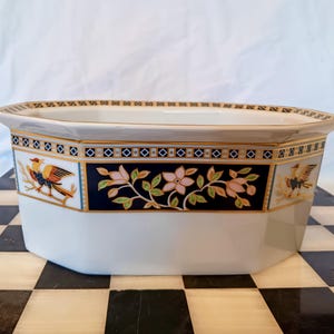 Könnte beinhalten: Weiße Servierschale aus Keramik mit achteckiger Form. Die Schale hat ein dekoratives Band mit marineblauem Hintergrund, goldenem Rand und Blumen- und Vogelmotiven. Der Rand hat einen goldenen Rand.