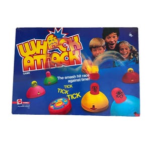 May include: A vintage Whack Attack game box with a blue background and the game's title in large, colorful letters. The box features images of children and adults playing the game, along with the text "The smash hit race against time!"