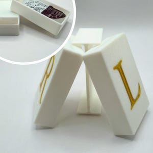 Könnte beinhalten: Ein Set aus drei Keramikbechern mit gesprenkelter, matter Oberfläche. Die Becher sind in den Farbtönen Creme, Hellgrau und Dunkelgrau gehalten. Jeder Becher hat ein schlichtes, modernes Design und einen abgerundeten Henkel.