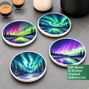 Può includere: Un set di quattro sottobicchieri rotondi con vivaci illustrazioni di aurore boreali su paesaggi innevati con pini e acqua riflettente. Ogni sottobicchiere mostra una scena notturna unica con giochi di luce colorati nelle tonalità del verde, viola e blu.