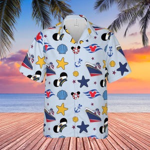 Op de afbeelding: Lichtblauwe button-down shirt met een nautisch thema. De shirt heeft verschillende cartoonafbeeldingen, waaronder Mickey Mouse, cruiseschepen, ankers, schelpen en sterren. De shirt heeft korte mouwen en een kraag.