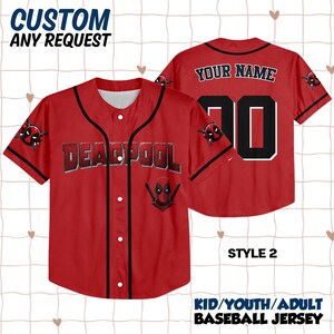 Op de afbeelding: Rood honkbalshirt met zwarte details, met het woord "DEADPOOL" op de borst en een Deadpool-logo. De achterkant heeft het nummer "20" en ruimte voor een naam. Honkbalshirt voor kinderen, jeugd of volwassenen.