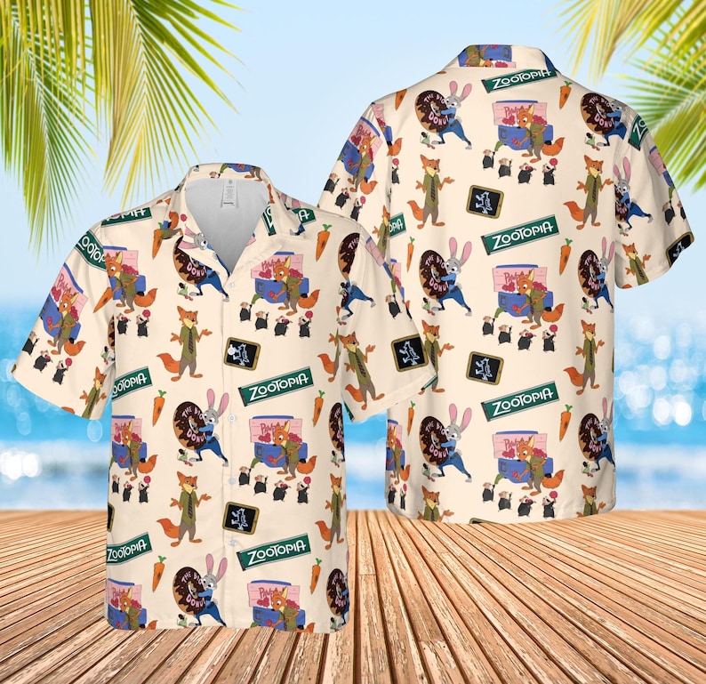 May include: A short-sleeved button-down shirt with a repeating pattern of characters and elements from the animated film "Zootopia." The shirt is primarily cream-colored, with images of a fox, a rabbit, and other characters. The word "Zootopia" is also visible.
