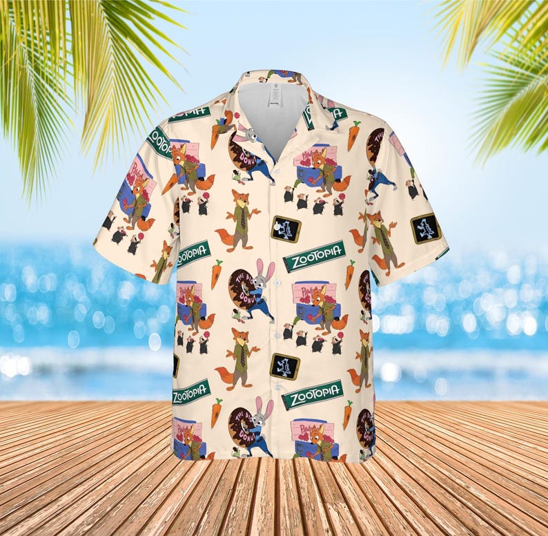 May include: Cream-colored button-down shirt with a repeating pattern of characters and imagery from the animated film "Zootopia." The design includes foxes, bunnies, carrots, and the film's logo. The shirt has short sleeves and a classic collar.