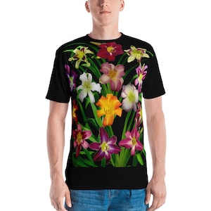 May include: A black t-shirt featuring a colourful floral print with a variety of lilies in shades of pink, purple, orange, yellow and white.