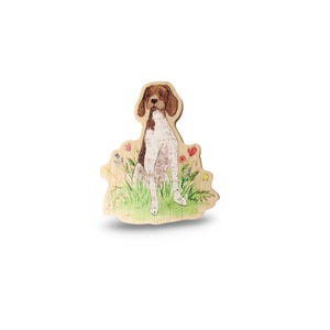 May include: A wooden cutout of a brown and white German Shorthaired Pointer dog sitting in a field of green grass with colorful flowers.