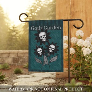 Könnte beinhalten: Eine rechteckige Gartenflagge mit einem blaugrünen Hintergrund und einem dezenten Punktemuster. Das Design zeigt drei schwarze Blumen mit weißen menschlichen Schädeln in der Mitte, begleitet von grauen Blättern. Der Text Goth Garden ist weiß gedruckt.