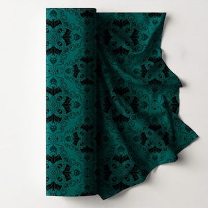 Può includere: Un tessuto turchese arrotolato con un motivo nero ripetuto di pipistrelli, teschi e volute ornate. Il tessuto è piegato, rivelando il design dettagliato. Il tema generale è gotico e spettrale.