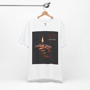 May include: White t-shirt with a graphic featuring a lit match held by a hand, with the text "FJALET E QIRIRIT" and "Naim Frashëri" in red. The design is centered on the shirt.