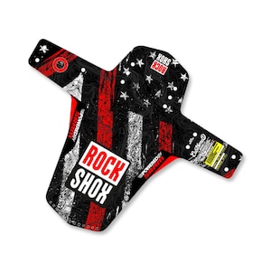 Peut inclure: Garde-boue de vélo de montagne noir, rouge et blanc avec un motif graphique. Le garde-boue présente le texte "ROCK SHOX" dans un encadré blanc, des étoiles et des rayures. Le texte "POWERED BY SRAM" est également visible.