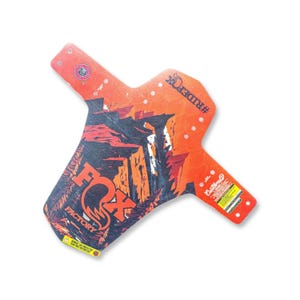 May include: A mountain bike fender with a vibrant orange and black design. The fender features the "FOX FACTORY" logo and a landscape graphic. Text includes "#RIDEFOX" and "Custom".