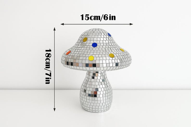 Pu&ograve; includere: Un oggetto decorativo a forma di fungo ricoperto da piccole piastrelle a specchio riflettenti. Il fungo &egrave; alto 18 cm e largo 15 cm, con accenti colorati.