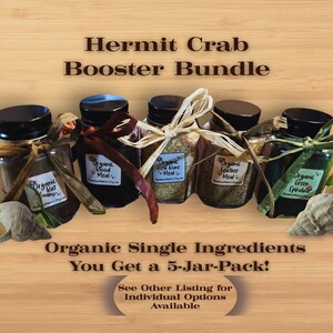 May include: A Hermit Crab Booster Bundle featuring five small glass jars with black lids, tied with natural twine and ribbons. Each jar contains organic ingredients like guano, blood meal, and spirulina. The text reads "Organic Single Ingredients You Get a 5-Jar-Pack!"