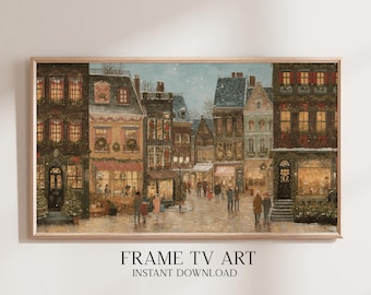 Pode incluir: Impressão emoldurada de uma praça de cidade europeia nevada. Os edifícios são adornados com decorações de Natal. O texto "FRAME TV ART INSTANT DOWNLOAD" está na parte inferior da imagem.