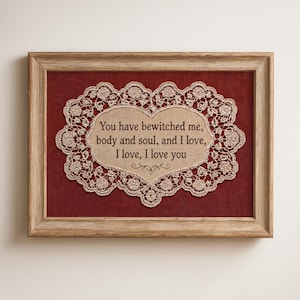 Może przedstawiać: Oprawiona grafika z koronkowym wzorem w kształcie serca i cytatem "You have bewitched me, body and soul, and I love, I love, I love you." Grafika jest umieszczona na czerwonym tle i oprawiona w jasnobrązową ramę.