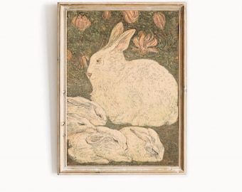 May include: Framed vintage print featuring a white rabbit with three smaller rabbits below. The background is a dark green with peach-colored floral accents. The frame is a light, neutral color.