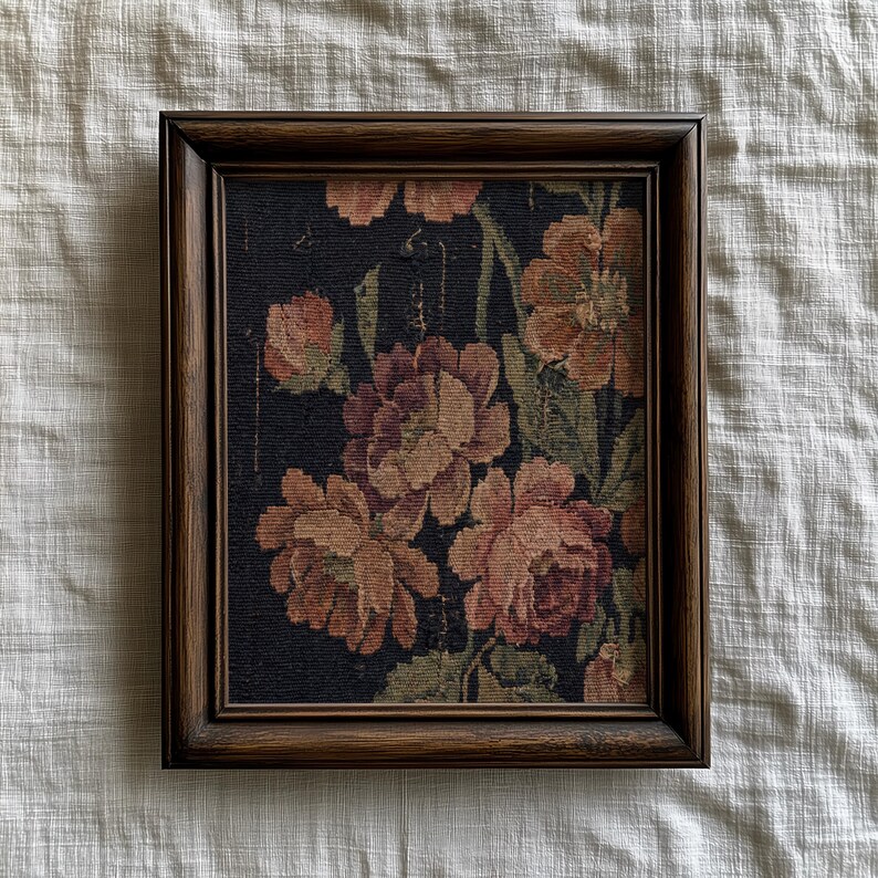 Puede incluir: Un tapiz floral enmarcado con grandes flores melocot&oacute;n y burdeos sobre un fondo oscuro. Las flores tienen hojas y tallos verdes. El marco es de madera marr&oacute;n oscuro.