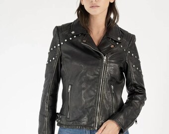 May include: Black leather jacket with silver-tone stud embellishments on the shoulders and sleeves. The jacket features a notched collar, an asymmetrical zipper closure, and multiple zippered pockets. The model is wearing blue jeans.