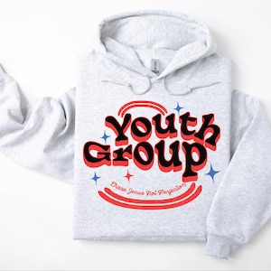 May include: A light gray hoodie with the words "Youth Group" in a retro font, outlined in red and black. The text "Chase Jesus Not Perfection" is below. Blue and red starburst graphics are also present.