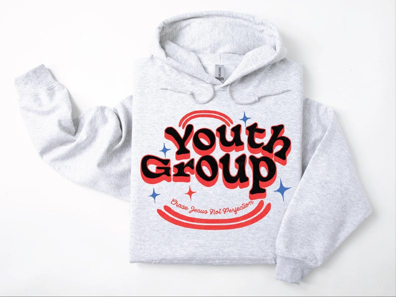 May include: A light gray hoodie with the words "Youth Group" in a retro font, outlined in red and black. The text "Chase Jesus Not Perfection" is below. Blue and red starburst graphics are also present.