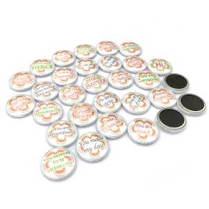 May include: A collection of 20 round, white button magnets with colourful floral designs and positive affirmations. The magnets feature phrases like "You are special", "You are loved", "You are awesome", and "You bring joy".