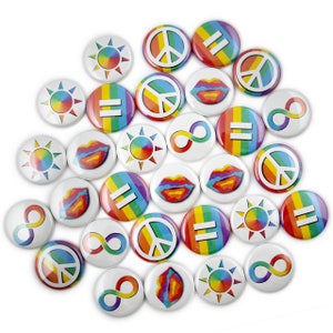 May include: A collection of colorful round buttons with various symbols, including peace signs, infinity symbols, equal signs, lips, and sunbursts. The buttons are arranged in a circular pattern on a white background.