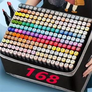 Puede incluir: Un estuche negro que contiene 168 rotuladores de colores. Los rotuladores están dispuestos en filas y columnas, cada uno con un color y un número diferente. El estuche está abierto, revelando los rotuladores en su interior.