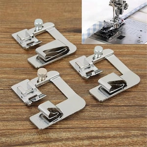 Puede incluir: Tres prensatelas de metal plateado para máquina de coser, diseñados para dobladillos, con base plana, guía de dobladillo enrollado y tornillo de ajuste vertical. Un recuadro muestra uno de estos prensatelas unido a una aguja de coser.