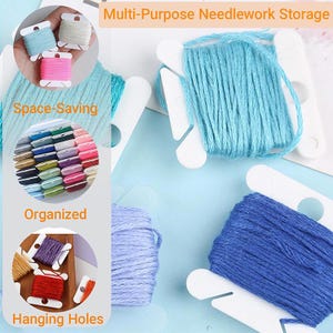 Può includere: Rocchetti in plastica bianca avvolti con filo da ricamo di vari colori, tra cui azzurro, blu scuro e lavanda. L'immagine include le scritte: Multi-Purpose Needlework Storage, Space-Saving, Organized e Hanging Holes.