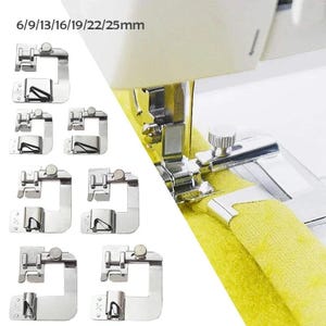 Könnte beinhalten: Ein Set aus silberfarbenen Nähmaschinen-Saumfüßen in verschiedenen Größen, beschriftet mit 6/9/13/16/19/22/25mm. Das Bild zeigt mehrere einzelne Nähfüße sowie eine Nahaufnahme eines an einer Nähmaschine befestigten Fußes, der einen gelben Stoffsaum faltet.