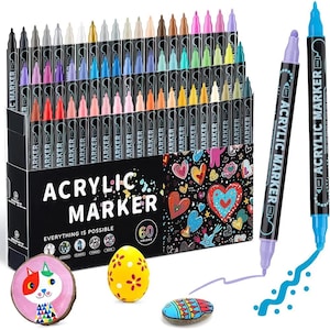 Puede incluir: Un juego de 60 rotuladores acrílicos de varios colores, presentados en una caja negra con las palabras "ACRYLIC MARKER" y "EVERYTHING IS POSSIBLE". La imagen también muestra piedras y un huevo pintados.
