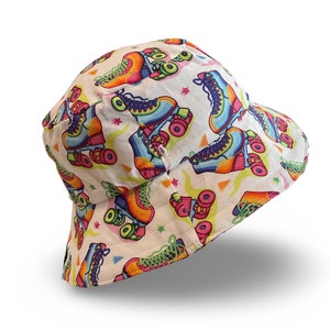 May include: A white bucket hat with a colourful roller skate pattern. The hat has a wide brim and a flat crown.