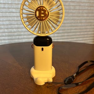 Ventilador portátil eléctrico Bitcoin, ventilador recargable con símbolo de bitcoin, soporte para teléfono celular en la base del ventilador. 5 velocidades de viento.