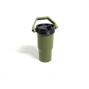 Puede incluir: Vaso t&eacute;rmico verde oliva con tapa negra y asa verde a juego. El vaso cil&iacute;ndrico tiene un asa fijada a la tapa. Dise&ntilde;ado para mantener las bebidas fr&iacute;as o calientes. Altura aproximada: 18 cm.