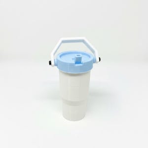 Puede incluir: Un vaso blanco con tapa y asa azul claro. La tapa tiene una abertura abatible. El asa es blanca y est&aacute; sujeta al vaso con bisagras negras. El vaso est&aacute; dise&ntilde;ado para contener bebidas.