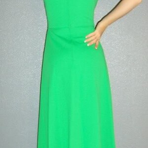 Puede incluir: Un vestido maxi verde brillante con cuello alto y sin mangas. El vestido tiene una silueta simple y elegante.