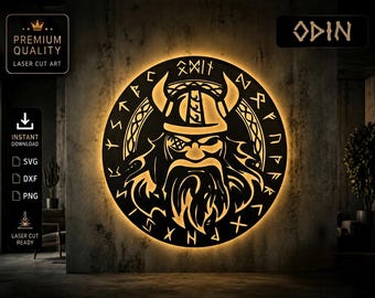 May include: A circular laser-cut wall art piece depicting Odin, a figure from Norse mythology. The artwork features a detailed image of Odin wearing a horned helmet, surrounded by runic symbols. The piece is illuminated with a warm, golden light.