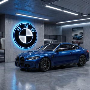 May include: A blue BMW sports car is parked inside a modern garage. The car is centered in the frame, with the BMW logo illuminated on the wall behind it. The garage has cabinets, tools, and posters.