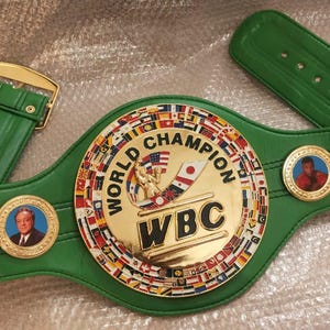 Pu&ograve; includere: Una cintura verde del campionato del World Boxing Council (WBC) con fibbia e medaglioni dorati. Il centro presenta un emblema dorato con le parole "WORLD CHAMPION" e "WBC". La cintura ha un cinturino in pelle verde.