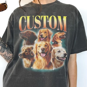 May include: Dark gray t-shirt featuring a graphic of several golden retriever faces with the word "CUSTOM" in a gradient yellow and orange font. The shirt has a vintage, worn look.