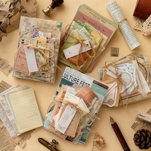 May include: A collection of vintage-style paper ephemera sets, including stacks of patterned cards, postcards, and notes tied with twine. The items feature floral prints, newspaper clippings, and text like "Culture Fest" and "Maison de Gros."