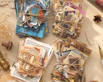 May include: Four stacks of assorted paper ephemera tied with brown twine. The stacks feature various designs including blue landscape art, vintage floral patterns, beige document-style prints, and sepia-toned newspaper clippings with text.