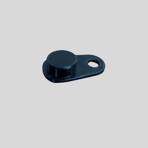 May include: A small, black plastic component with a circular top and a rectangular base with a hole. The object is likely a fastener or a small part for a larger assembly.