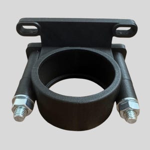 May include: A black, industrial-style bracket with a circular opening and two bolts. The bracket has a rectangular top section with two holes for mounting. The bolts are silver and secure the bracket's side arms.