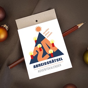 May include: A white rectangular paper card with a dark blue triangle graphic featuring the orange number 24, a star, and four red candles with yellow flames. The text reads "abreißen öffnen knobeln" and "ABREISSRÄTSEL ADVENTSKALENDER".