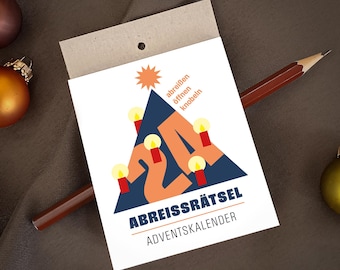 Könnte beinhalten: Eine weiße rechteckige Papierkarte mit einem dunkelblauen Dreieck, der orangen Zahl 24, einem Stern und vier roten Kerzen mit gelben Flammen. Der Text lautet "abreißen öffnen knobeln" und "ABREISSRÄTSEL ADVENTSKALENDER".