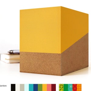 Op de afbeelding: Een gele en bruine bureau-organizer met een geometrisch ontwerp. De bovenste helft van de organizer is geel en de onderste helft is bruin.