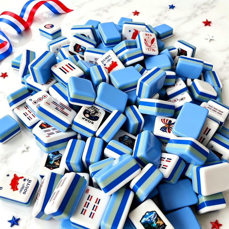 Puede incluir: Un gran mont&oacute;n de fichas de mahjong rectangulares con lados a rayas en azul claro, azul medio y blanco. Las fichas muestran varios gr&aacute;ficos impresos, incluidos s&iacute;mbolos patri&oacute;ticos en rojo, blanco y azul, texto como 1776 y peque&ntilde;os confeti en forma de estrella.
